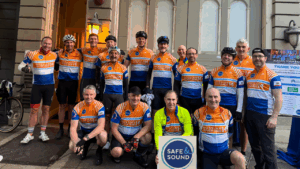 A group of 16 men in branded cycling jerseys