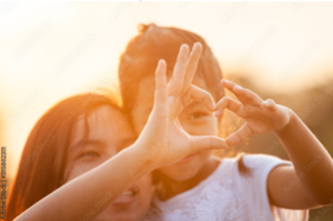 two children make a heart sign with their hands