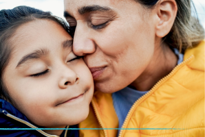 Photo of mother kissing their child.