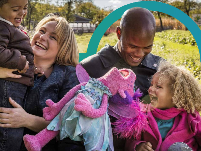 Image of 2 adults and 2 children having fun with a Sesame Street character