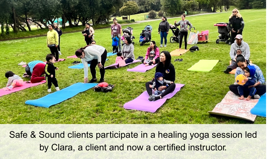 Image of adults and children taking part in a yoga class in the park. Caption reads: Safe & Sound clients participate in a healing yoga session led by Clara, a client and now a certified instructor.