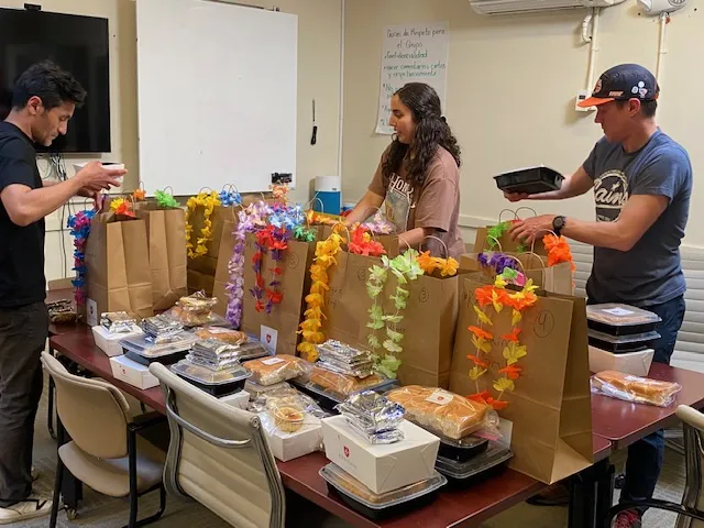 Image of Safe & Sound colleagues packing Community Dinner take-away bags for local families.