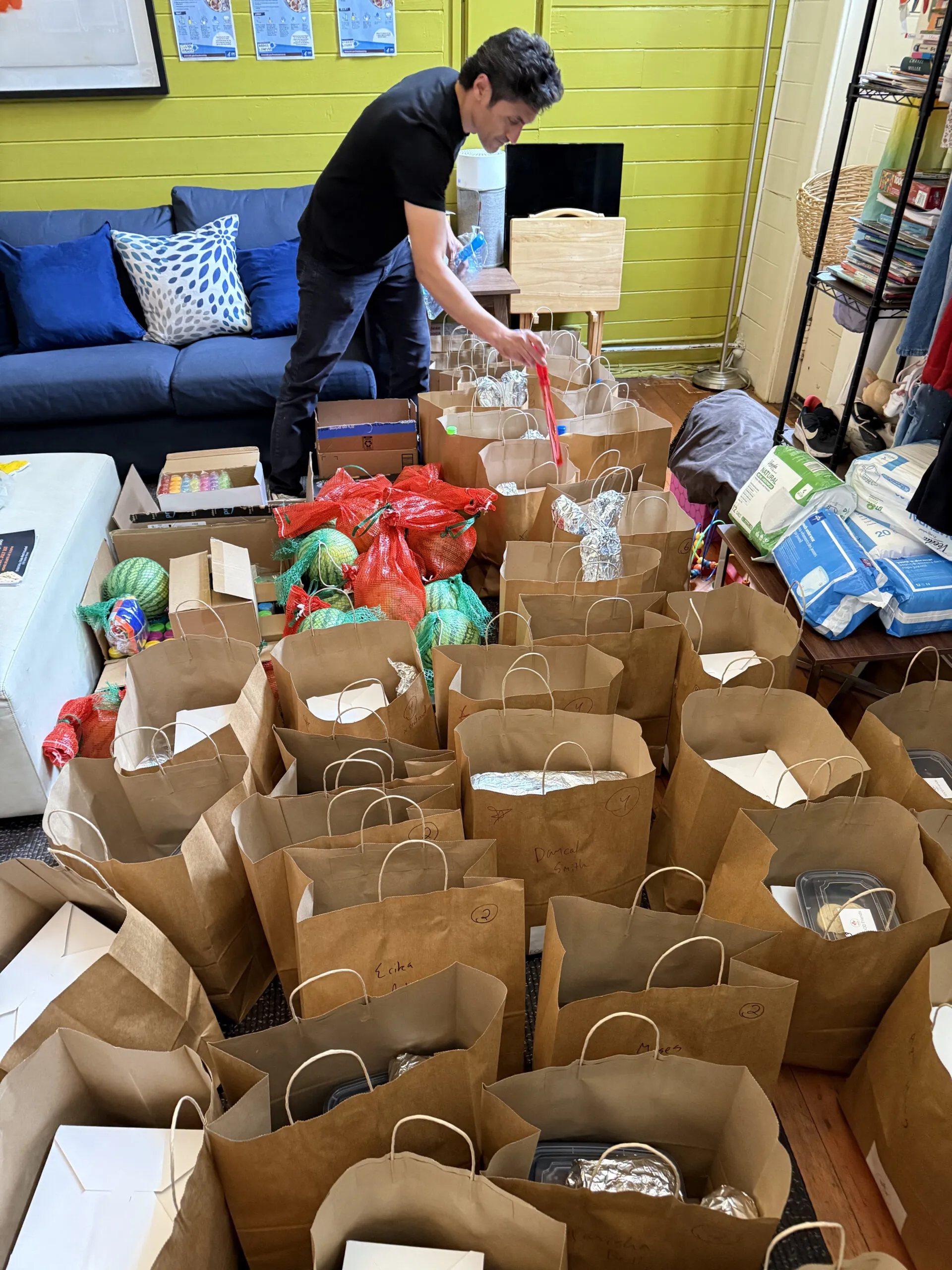 Image of a room full of Community Dinner take-away bags for local families.
