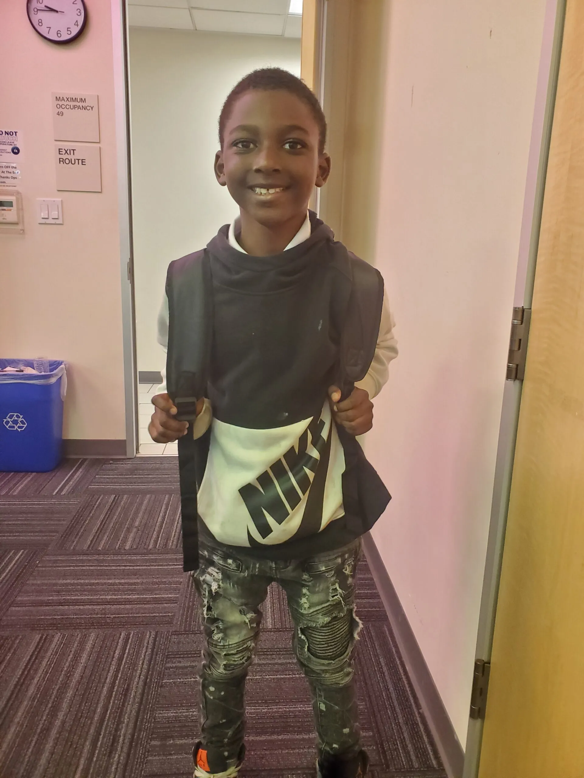 A child smiling with a new backpack