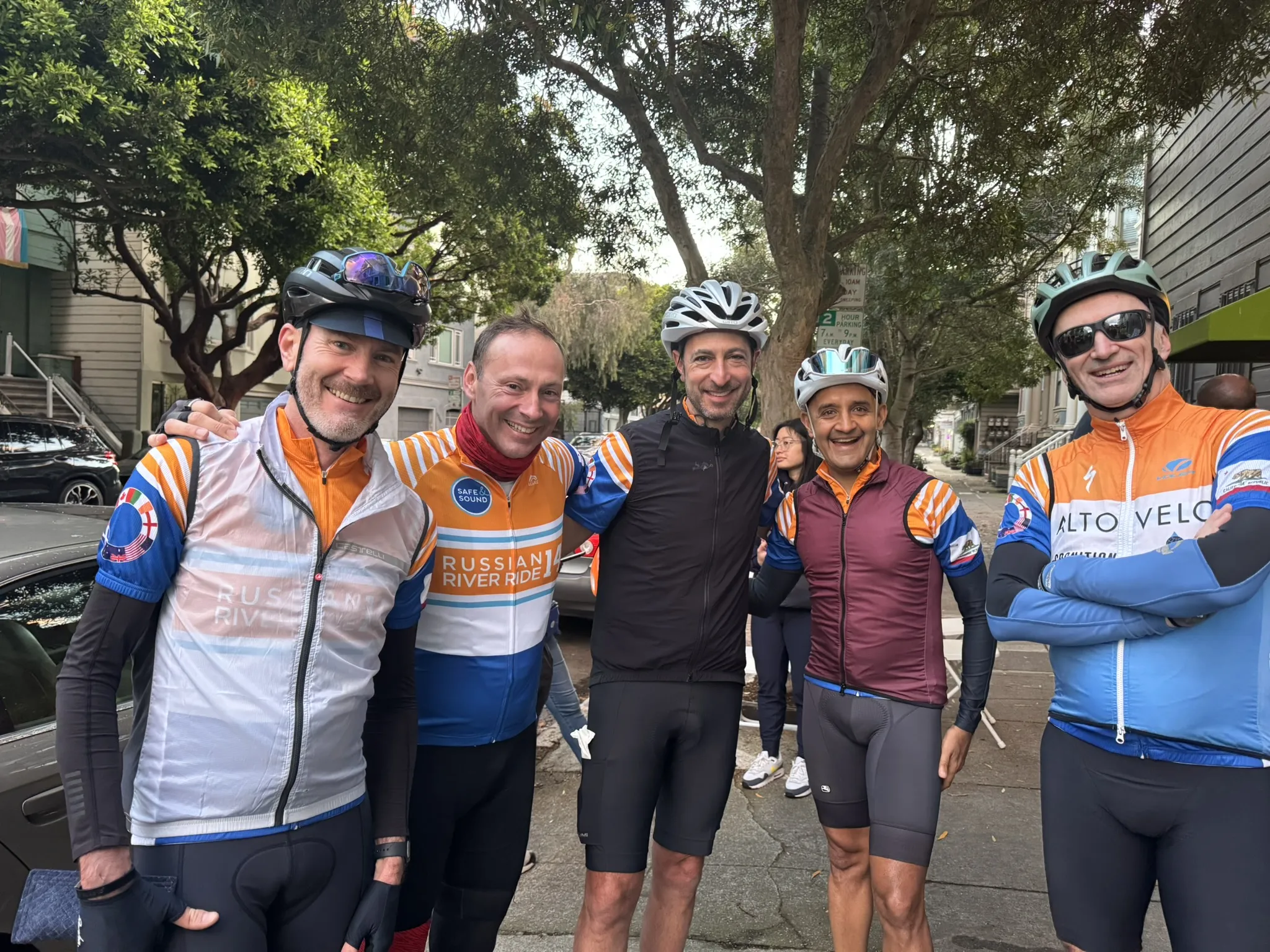 A group of 5 men in cycling jerseys and helmets