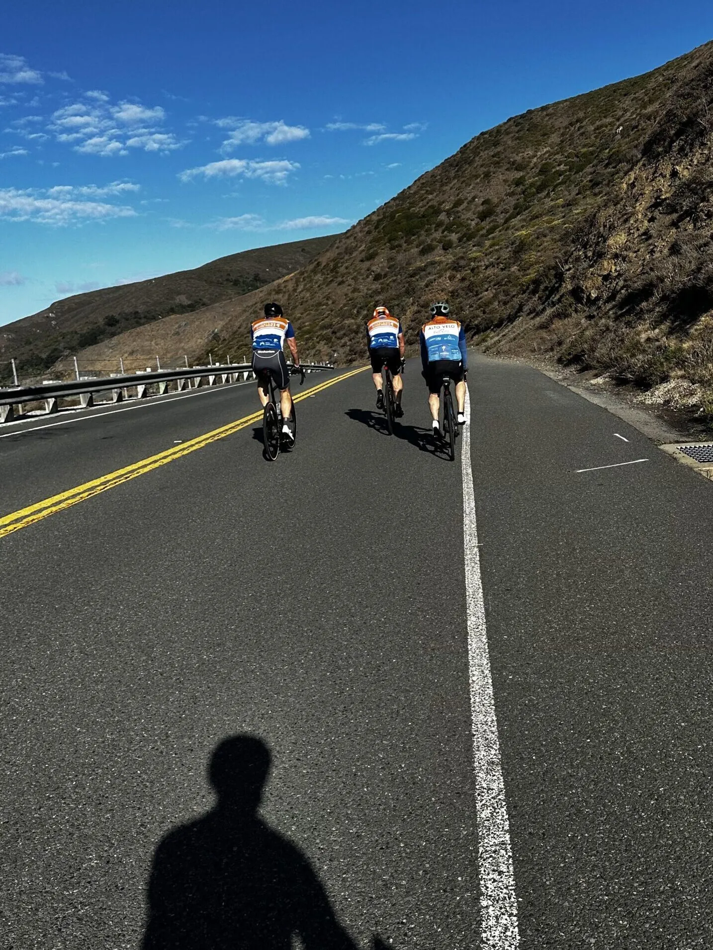 3 people cycle along a road